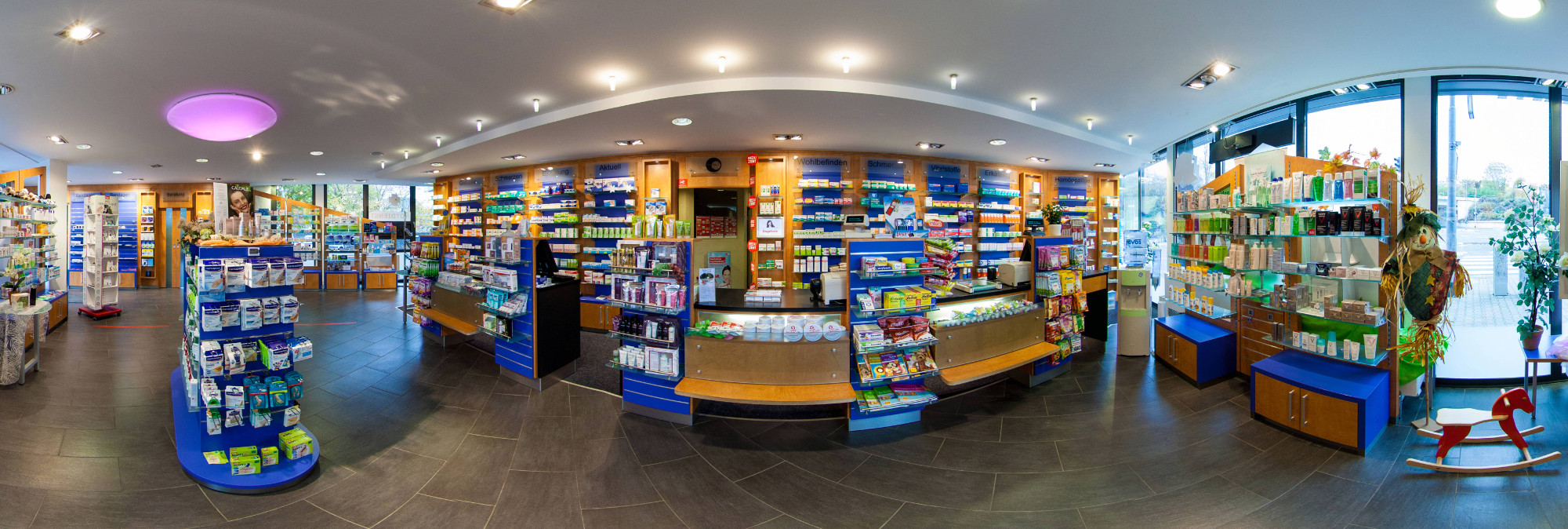 Panorama-Innenansicht der Apotheke am Damm - Verkaufsraum mit Regalen und Beratungsbereich